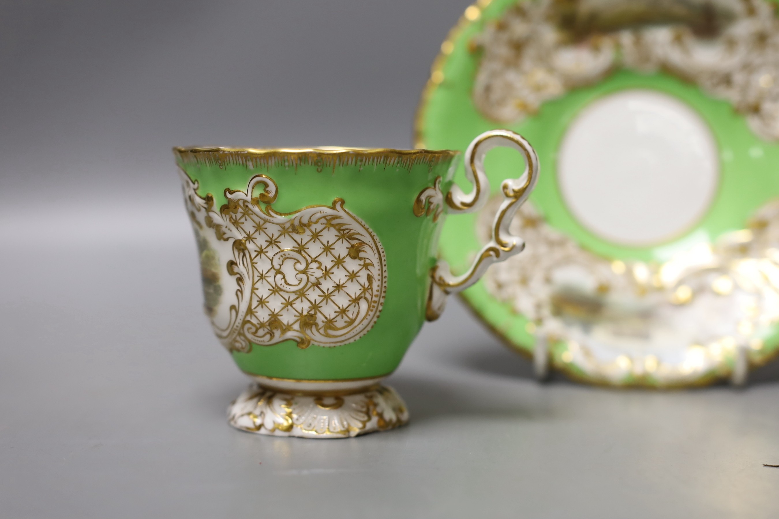 Copeland and Garrett fine topographical pedestal coffee cup and saucer with green ground painted with Sion House on the cup and Lincoln and Malsbury Abbey on the saucer c. 1840